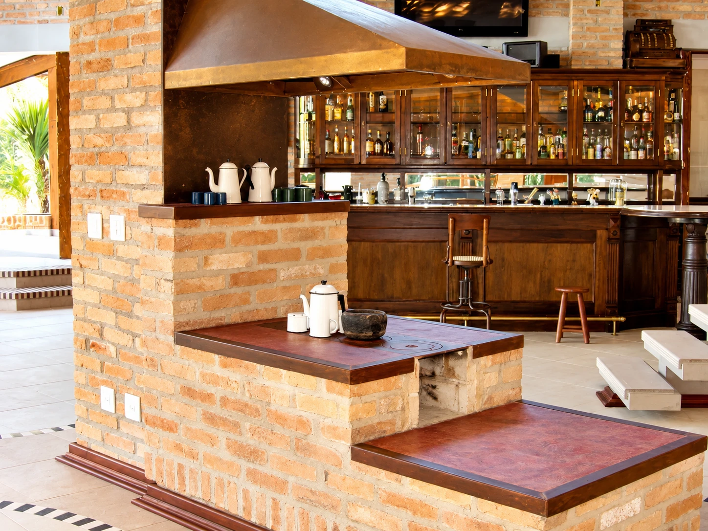 Espaço gourmet com bar em tijolo e bancada sob medida